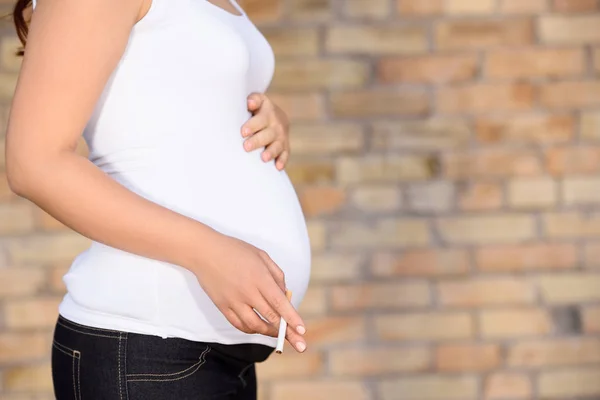 Беременная женщина с сигаретой — стоковое фото