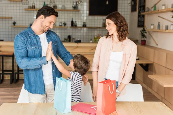 Familia joven con bolsas de compras - foto de stock