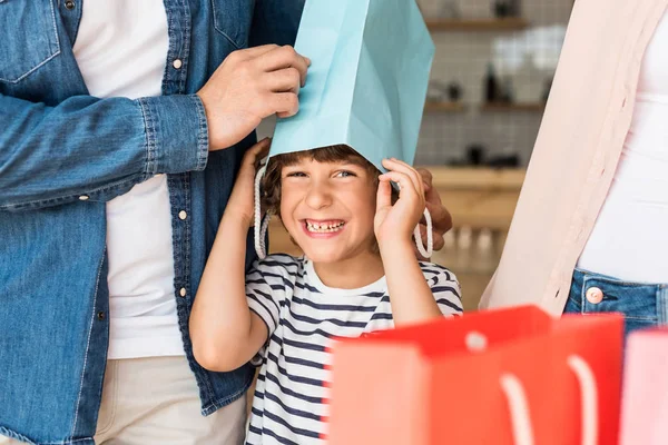 Niño con bolsa de compras en la cabeza - foto de stock