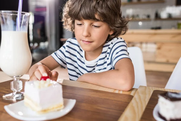 Boy with piece of cake in cafe — Stock Photo