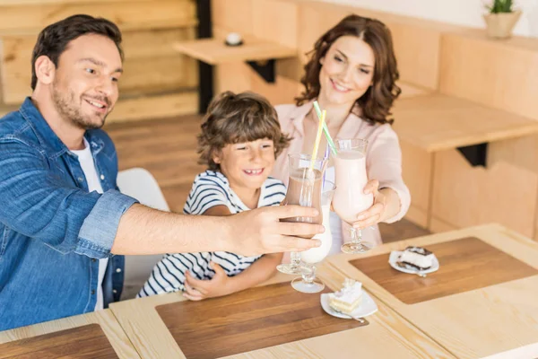 Family drinking milkshakes in cafe — Stock Photo