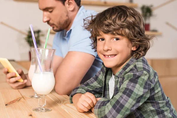 Son and father drinking milkshakes — Stock Photo