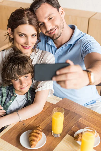 Family taking selfie in cafe — Stock Photo