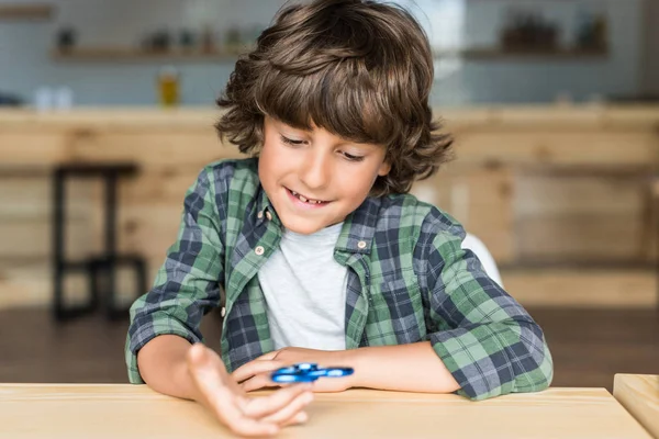 Sonriente chico con fidget spinner - foto de stock