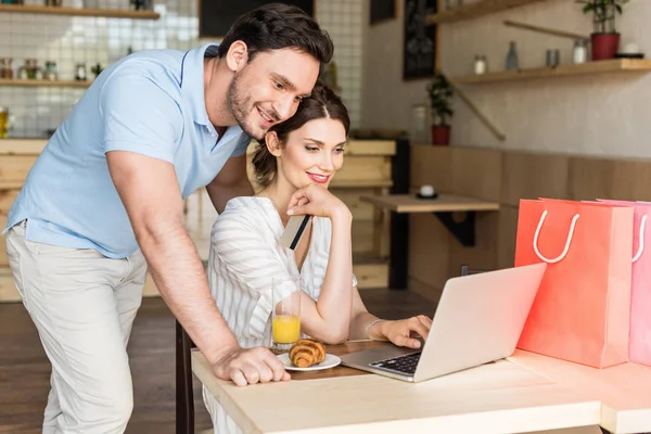 Couple using laptop in cafe — Stock Photo