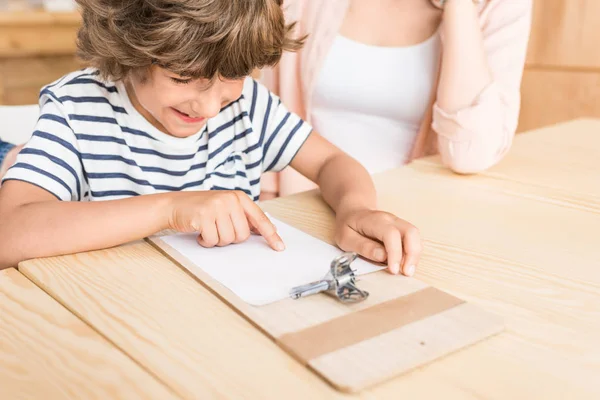 Мальчик, указывающий на бланковую бумагу — стоковое фото