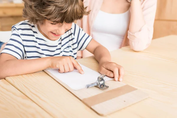 Chico apuntando al papel en blanco - foto de stock