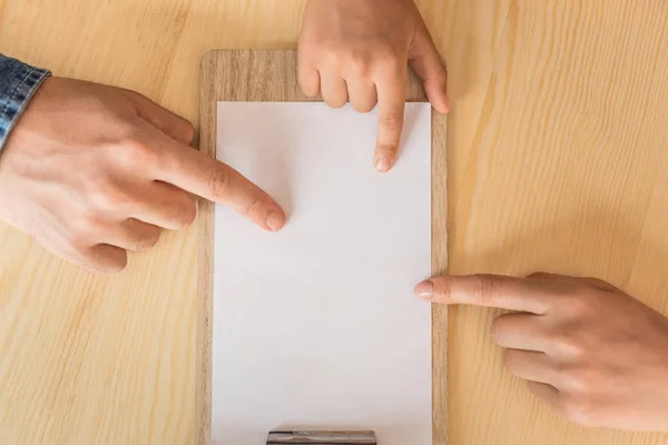 Family pointing at blank paper — Stock Photo
