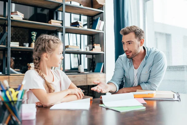 Padre haciendo la tarea con su hija - foto de stock