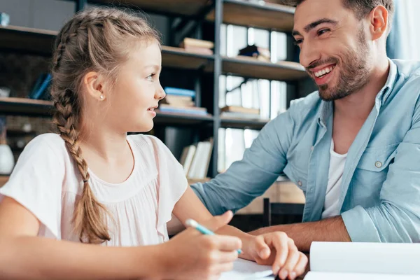 Pai fazendo lição de casa com a filha — Fotografia de Stock