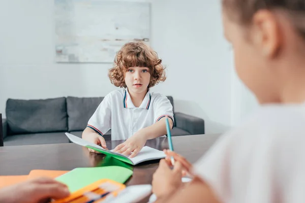 Boy doing homework with sister — Stock Photo