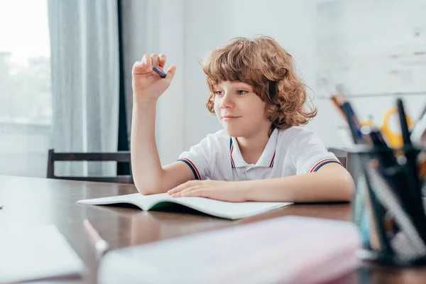 Curly boy doing homework — Stock Photo