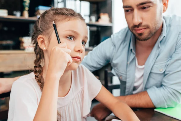 Pai fazendo lição de casa com a filha — Stock Photo