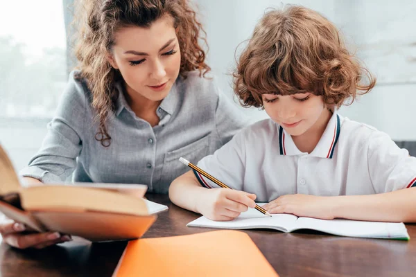 Mother and son doing homework — Stock Photo