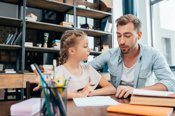 Father doing homework with daughter — Stock Photo