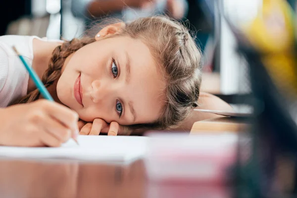 Маленькая девочка пишет домашнее задание — стоковое фото