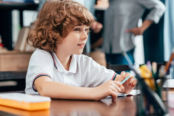 Ragazzo seduto alla scrivania della scuola — Foto stock