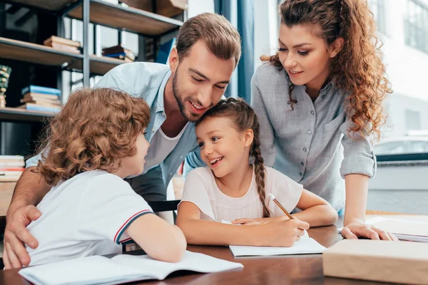 Eltern machen Hausaufgaben mit Kindern — Stockfoto