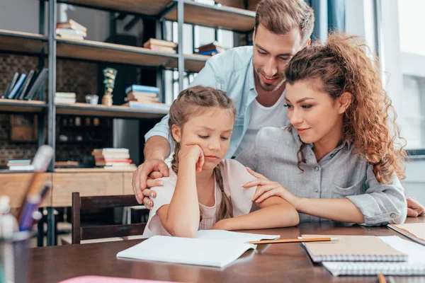 Parents faisant leurs devoirs avec leur fille — Photo de stock