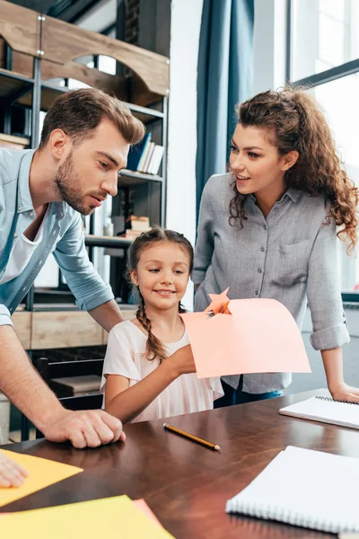 Parents faisant leurs devoirs avec leur fille — Photo de stock