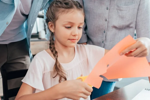 Маленькая девочка делает резьбу по бумаге — стоковое фото