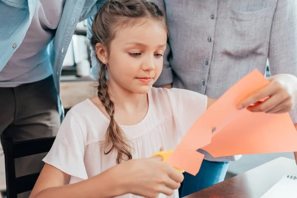 Little girl doing paper carving — Stock Photo