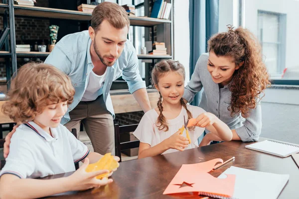 Padres haciendo deberes con niños - foto de stock