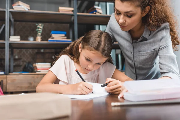 Mãe e filha fazendo lição de casa juntos — Fotografia de Stock