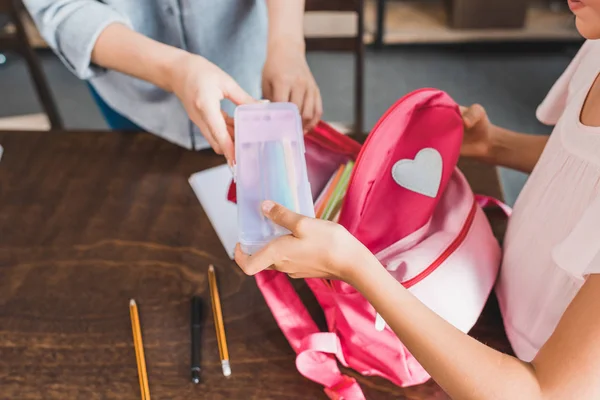 Mother and daughter preparing backpack for school — Stock Photo