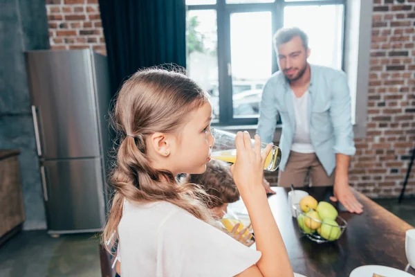 Niños bebiendo jugo de naranja - foto de stock