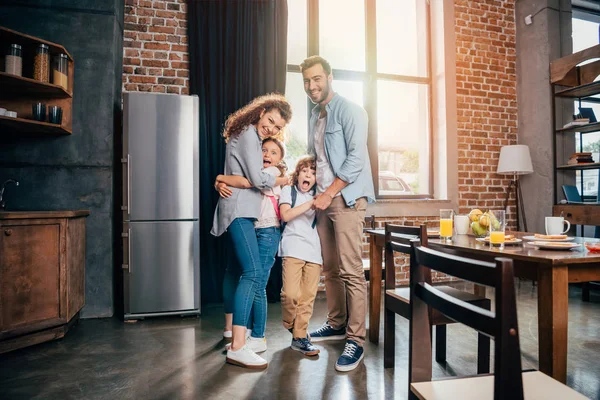 Familia abrazo en cocina - foto de stock