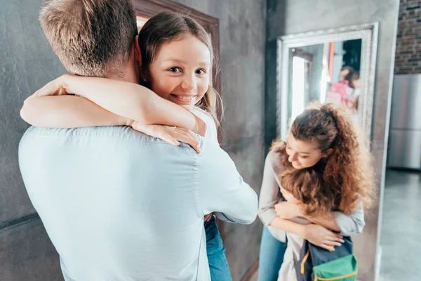 Genitori abbracciare i bambini prima di scuola — Foto stock