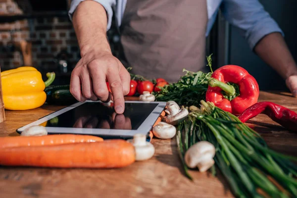 Hombre cocina con la tableta - foto de stock