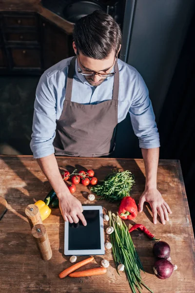 Hombre cocina con la tableta - foto de stock