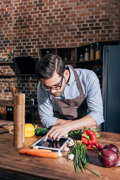 Uomo cucina con tablet — Foto stock