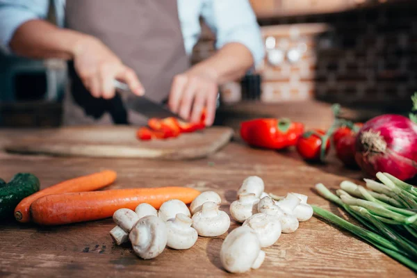 Verduras en la cocina con cocina de hombre - foto de stock