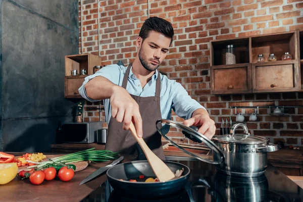 Junger Mann kocht — Stockfoto