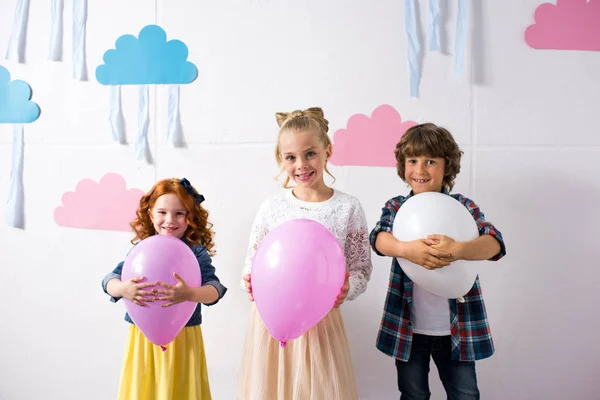 Adorables niños con globos - foto de stock