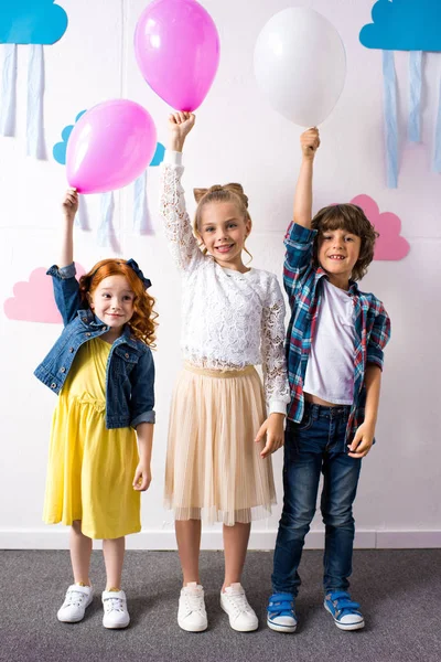 Adorables niños con globos - foto de stock