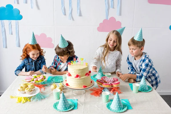 Niños felices en la mesa de cumpleaños - foto de stock