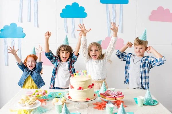 Niños felices en la mesa de cumpleaños - foto de stock