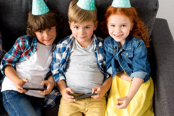 Niños usando gadgets en fiesta de cumpleaños - foto de stock