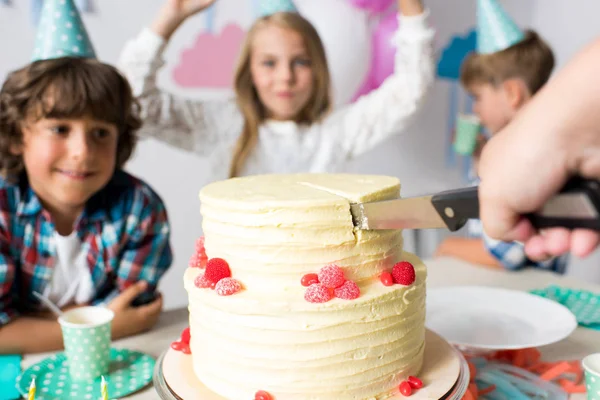 Hand schneidet Geburtstagstorte — Stockfoto