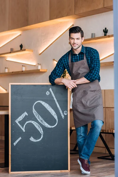Cameriere e lavagna con 50% offerta di vendita — Foto stock