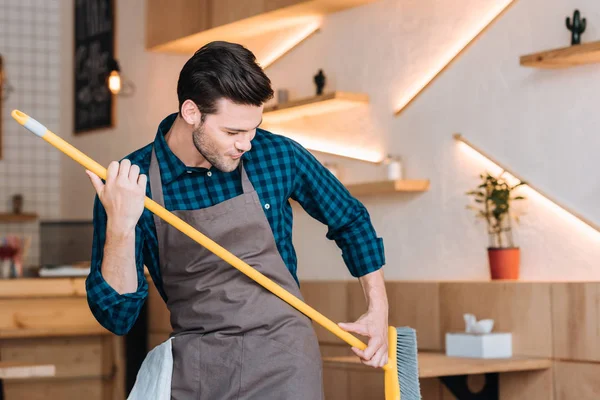 Homme s'amuser avec balai dans café — Photo de stock