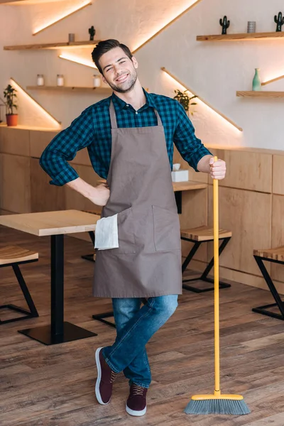 Trabajador con escoba en cafetería - foto de stock