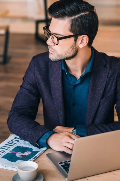 Pensive businessman with laptop in cafe — Stock Photo