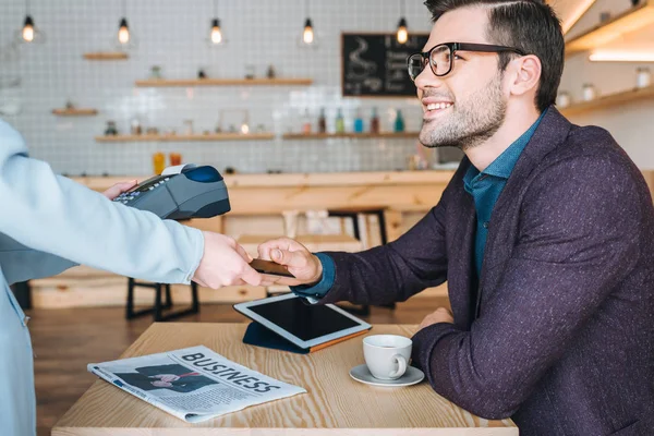 Hombre de negocios pagando con tarjeta de crédito en la cafetería - foto de stock