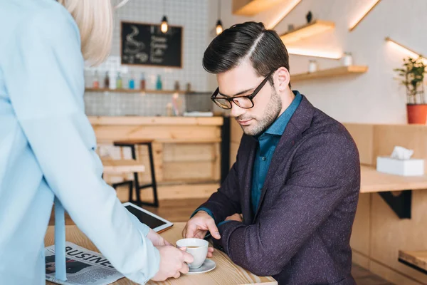 Serveuse avec ordre pour homme d'affaires à café — Photo de stock