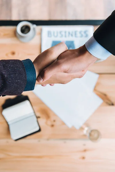 Empresarios estrechando la mano en la cafetería - foto de stock